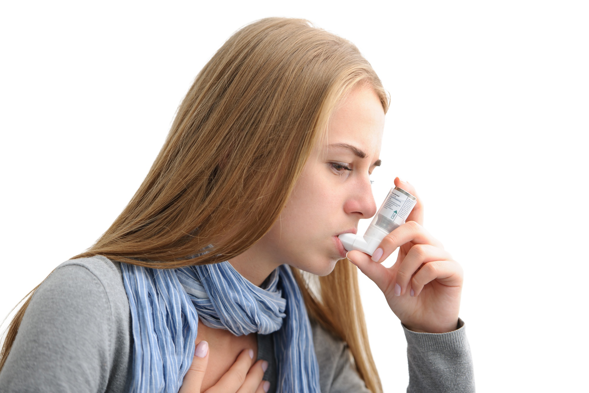 Young woman using an asthma inhaler as prevention